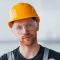 portrait-man-grey-uniform-protective-glasses-orange-hard-hat-that-standing-indoors-modern-big-office-daytime_1086199-14564